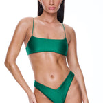 Woman wearing a green bikini set on a white background