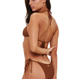 Woman wearing a brown bikini with a white background