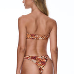 Woman wearing a leopard print bikini on a white background