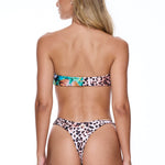 Woman wearing a leopard print bikini on a white background