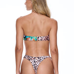 Woman wearing a leopard print bikini on a white background