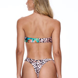 Woman wearing a leopard print bikini on a white background